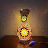 A handcrafted Turkish mosaic table lamp with a vibrant, colorful glass base and warm LED glow.
