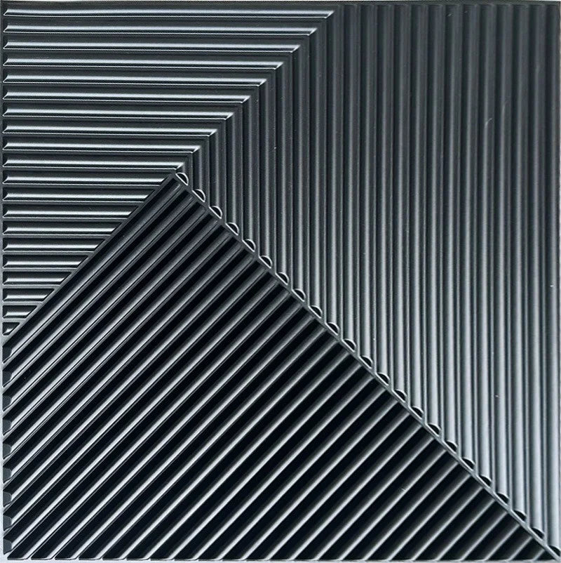 A close-up view of black, ribbed 3D diamond wall panels arranged in a sharp diagonal pattern.