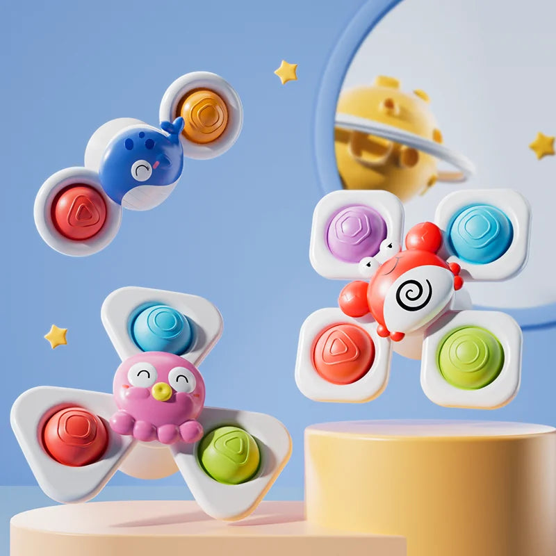 A colorful, ocean-themed spinning bath toy with various colored silicone discs is shown in flight against a light blue backgr