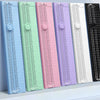 A row of colorful portable paper cutters or trimmers, featuring various shades of blue, green, pink, and purple.
