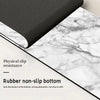Black rubber non-slip bottom mat placed on a white marble surface.