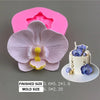 A pink silicone mold shaped like an orchid flower is shown next to a finished blue flower decoration.