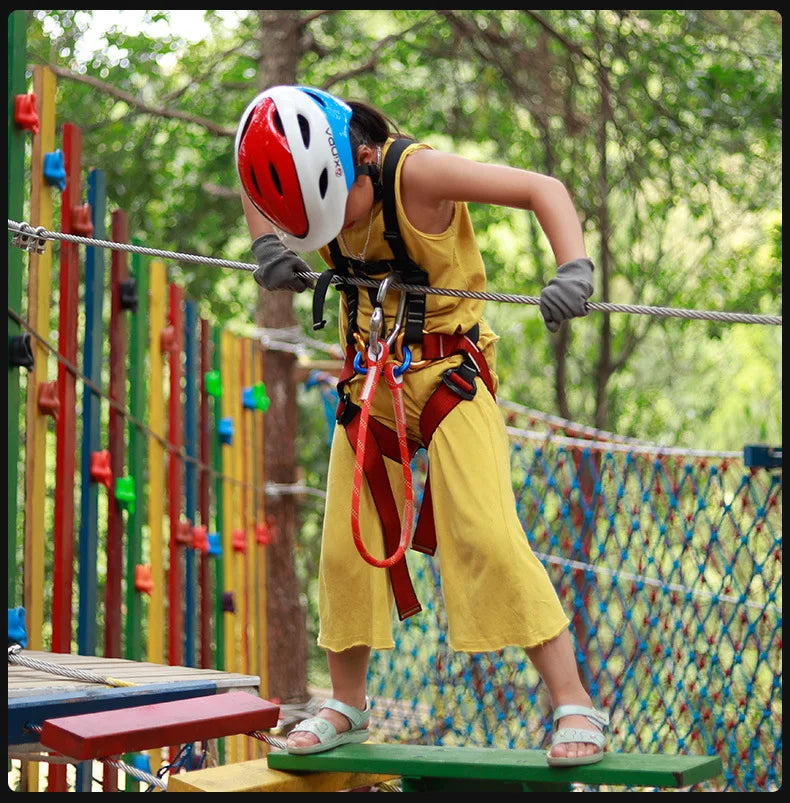 A person wearing a red helmet is using a pre-sewn nylon cord loop sling for climbing and rescue practice.