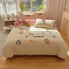 A beige duvet cover set featuring embroidered cartoon animals like bears and penguins on a bed.