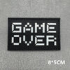 Black embroidered patch with white text GAME OVER on a gray background