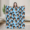 A blue cartoon throw blanket featuring multiple stylized characters with black hair and orange noses.