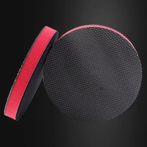 A black magic clay pad with a red and black grip is shown against a dark background.