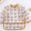 A white long sleeve smock and feeding bib featuring a repeating pattern of cute cat faces.