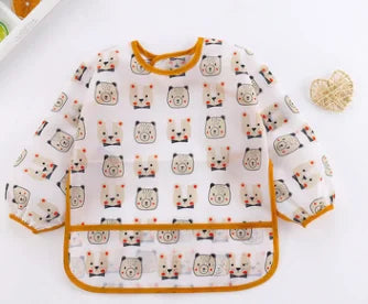 A white long sleeve smock and feeding bib featuring a repeating pattern of cute cat faces.