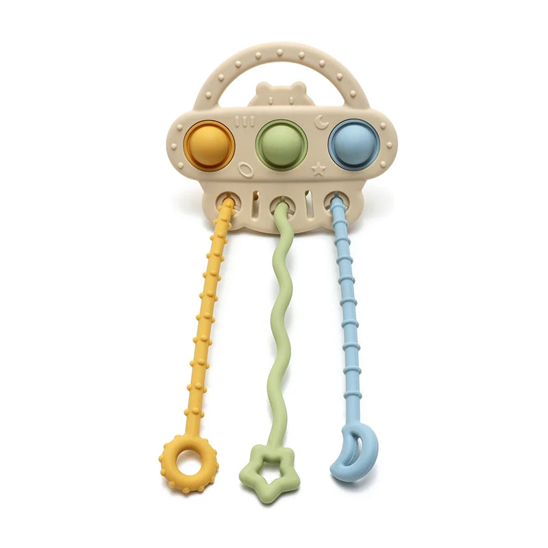 A silicone bear teether with a handle and pull strings, featuring round colored buttons.