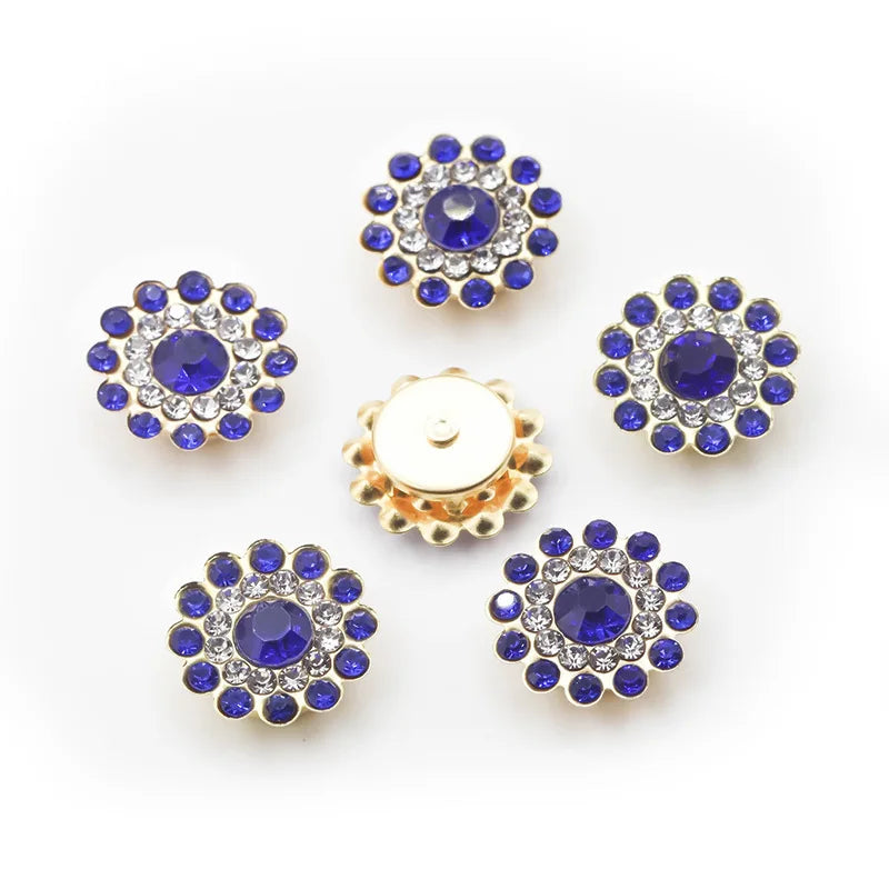A collection of twelve round, blue and clear rhinestones arranged in a circular pattern on a white background.