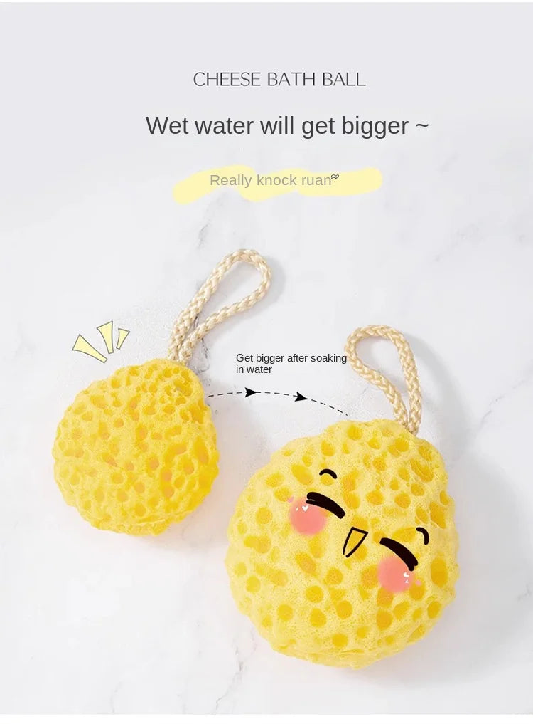 A yellow cheese bath ball made of soft mesh is shown soaking in water, demonstrating how it gets bigger.