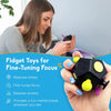 A hand holds a black fidget cube with yellow and blue pieces, demonstrating its use for focus and stress relief.