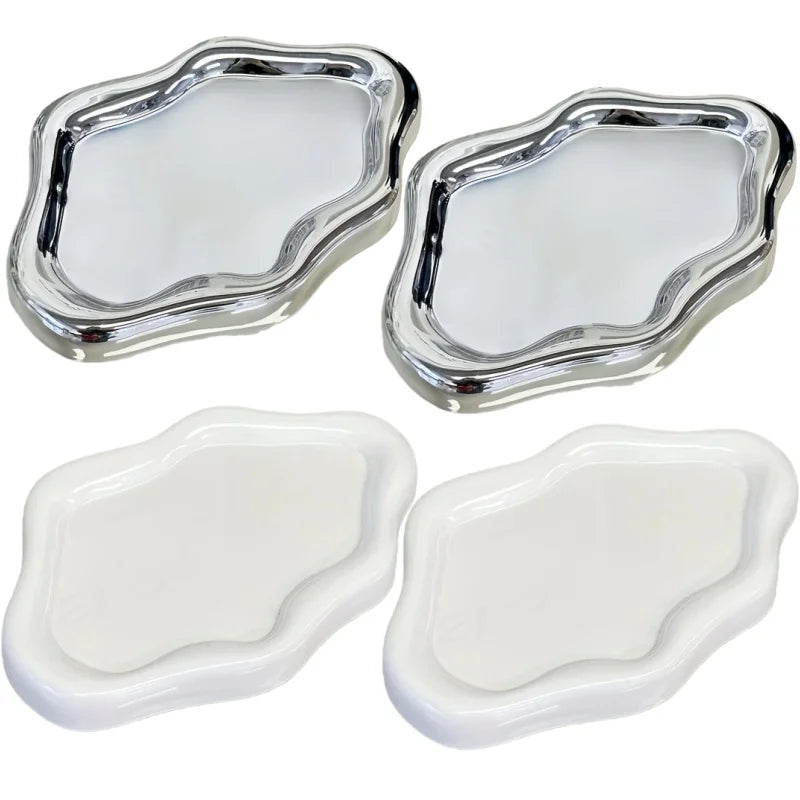 A set of two cloud-shaped jewelry trays, one silver and one white.