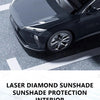 A close-up of a black car with a clear, iridescent laser diamond sunshade installed on the windshield.