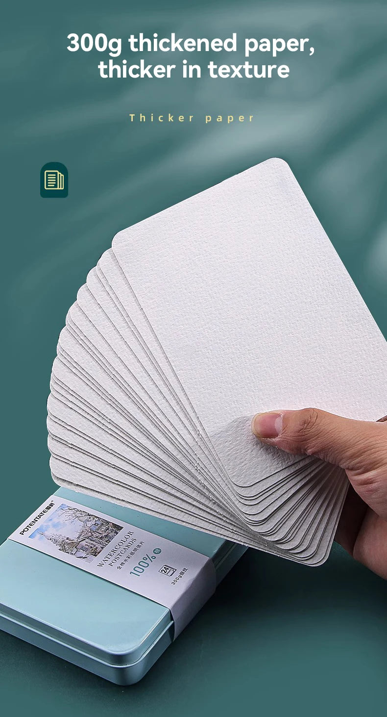 A stack of white thickened paper sheets is shown next to a tin box containing watercolor paper.