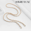 Gold-toned metal chain shoulder strap buckle for a crossbody bag.