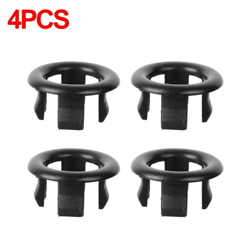 A set of four black chrome-plated sink overflow covers or stoppers.