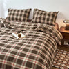 A plaid duvet cover in brown and cream tones with a grid pattern, displayed on a bed.