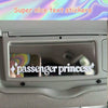 A close-up of a car mirror showing a passenger princess text sticker on the interior.