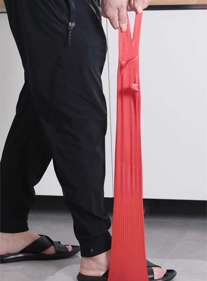 A person is holding a pair of bright orange silicone scrubbing dishwashing gloves.