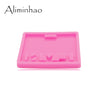 A pink silicone resin mold with various shapes for making badge backings and keychains.