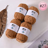 A collection of brown Milk Cotton yarn skeins with white labels and a pink tag marked #27.