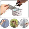 Hands are using scissors to cut and apply self-adhesive window screen repair tape onto a mesh surface.