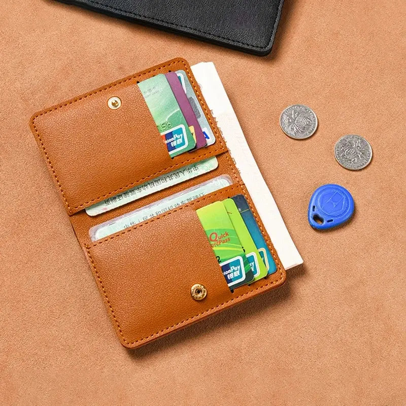 A brown leather compact wallet holding various credit cards and coins on a tan background.
