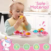 A baby is playing with a pink suction cup spinner sensory toy featuring various colors and shapes.
