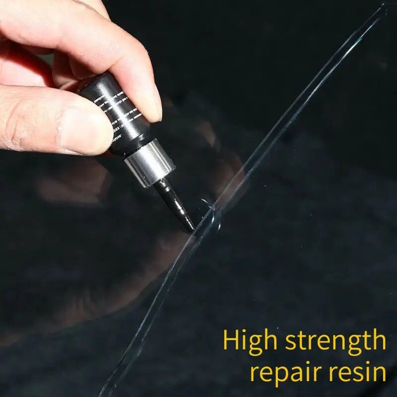 A hand applies a high strength repair resin to fix a crack in a glass surface.