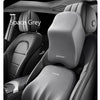 A close-up view of a grey memory foam car headrest pillow with shoulder support installed in a vehicle seat.