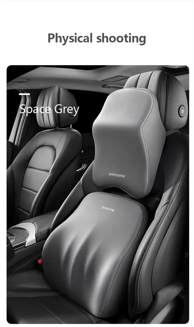 A close-up view of a grey memory foam car headrest pillow with shoulder support installed in a vehicle seat.