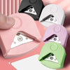 A collection of pink, white, purple, and green paper corner rounder cutters shown from an angled view.