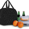 A black leopard print insulated lunch tote bag next to a glass bottle and an orange fruit.