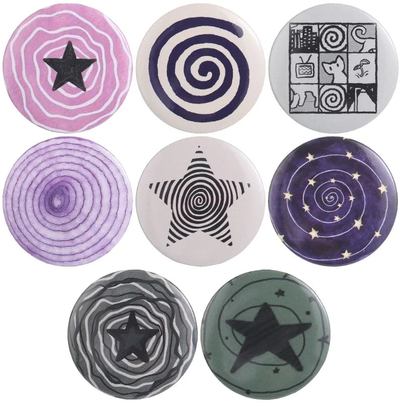 A collection of ten tinplate pin brooches featuring various designs including stars, spirals, and animals.