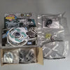 A set of premium metal spinning tops including a green and black top, a silver top, and various accessories in clear plastic 