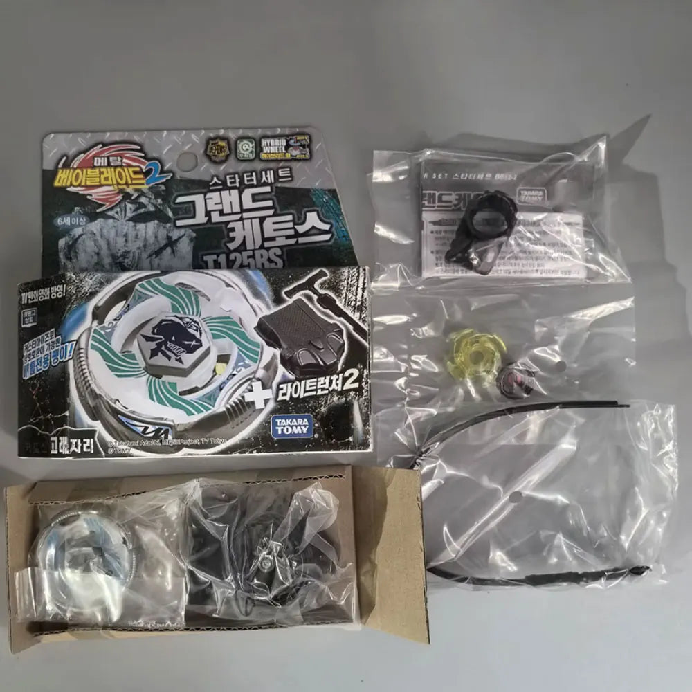 A set of premium metal spinning tops including a green and black top, a silver top, and various accessories in clear plastic 