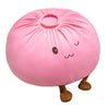 Un coussin en peluche rose, rond, en forme de dumpling mignon avec de petites pattes brunes.