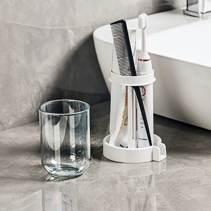 Organizador de tocador de baño blanco colgado en la pared, con peine y cepillo de dientes junto a una taza de vidrio.