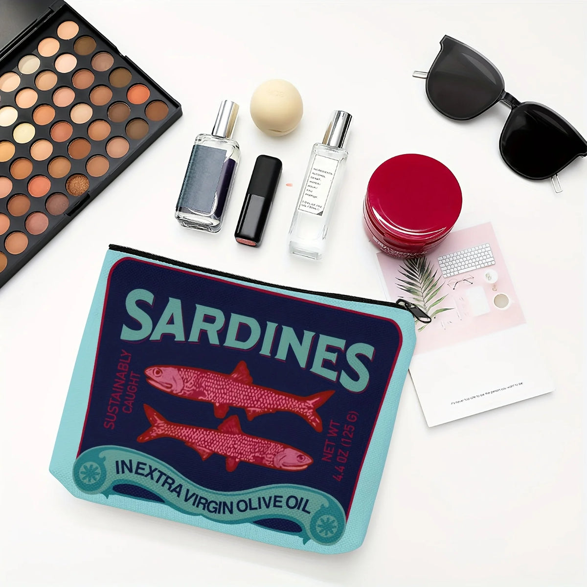Pochette de maquillage au design vintage de sardines et texte pour huile d'olive extra vierge, entourée de bouteilles en verr