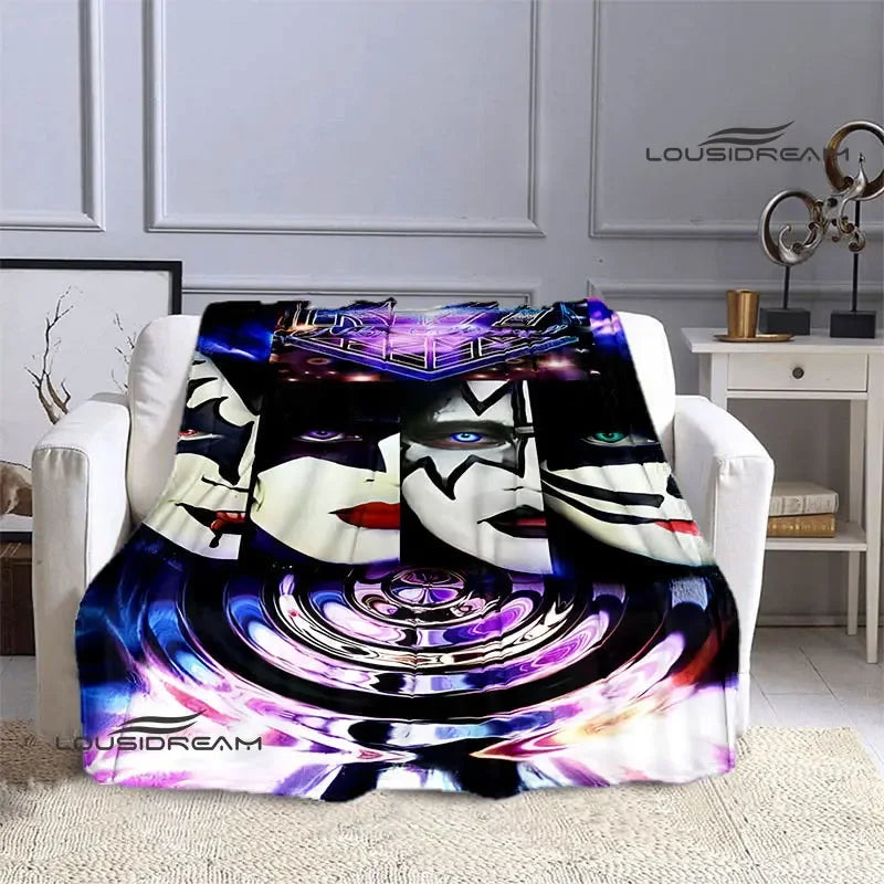 A purple and black printed flannel throw blanket featuring a stylized band image on a white sofa.