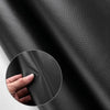 Close-up of black PU leather material showing texture and thickness being handled.