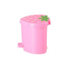 A pink strawberry-shaped mini trash can with a green lid.