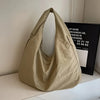 A beige lightweight nylon tote bag with a secure zipper closure is displayed on a white surface.
