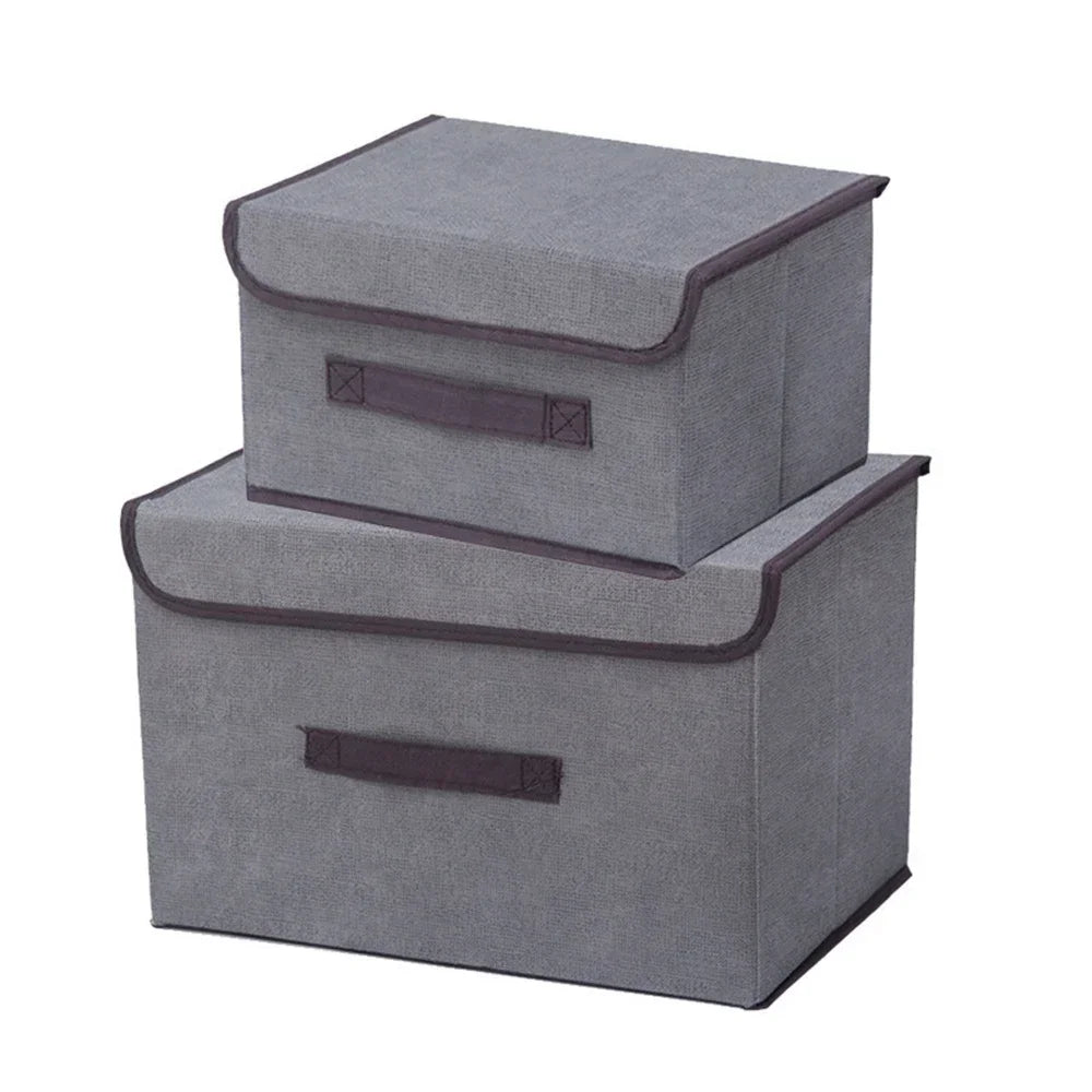 A set of two gray fabric storage boxes with dark brown trim for closet and drawer organization.