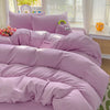 A purple cotton bedding set featuring a flat sheet, duvet cover, and pillowcases with a small purple stuffed elephant pillow.