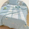 Light blue quilt featuring a pastoral print design with clouds, stars, and cute animal motifs on a bed.