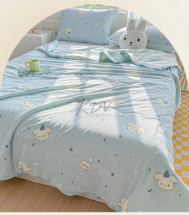 Light blue quilt featuring a pastoral print design with clouds, stars, and cute animal motifs on a bed.