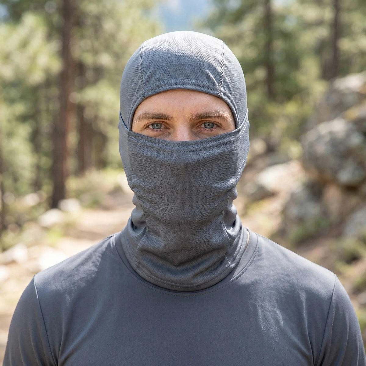 A man wearing a gray stretchy breathable balaclava cap for outdoor sports.